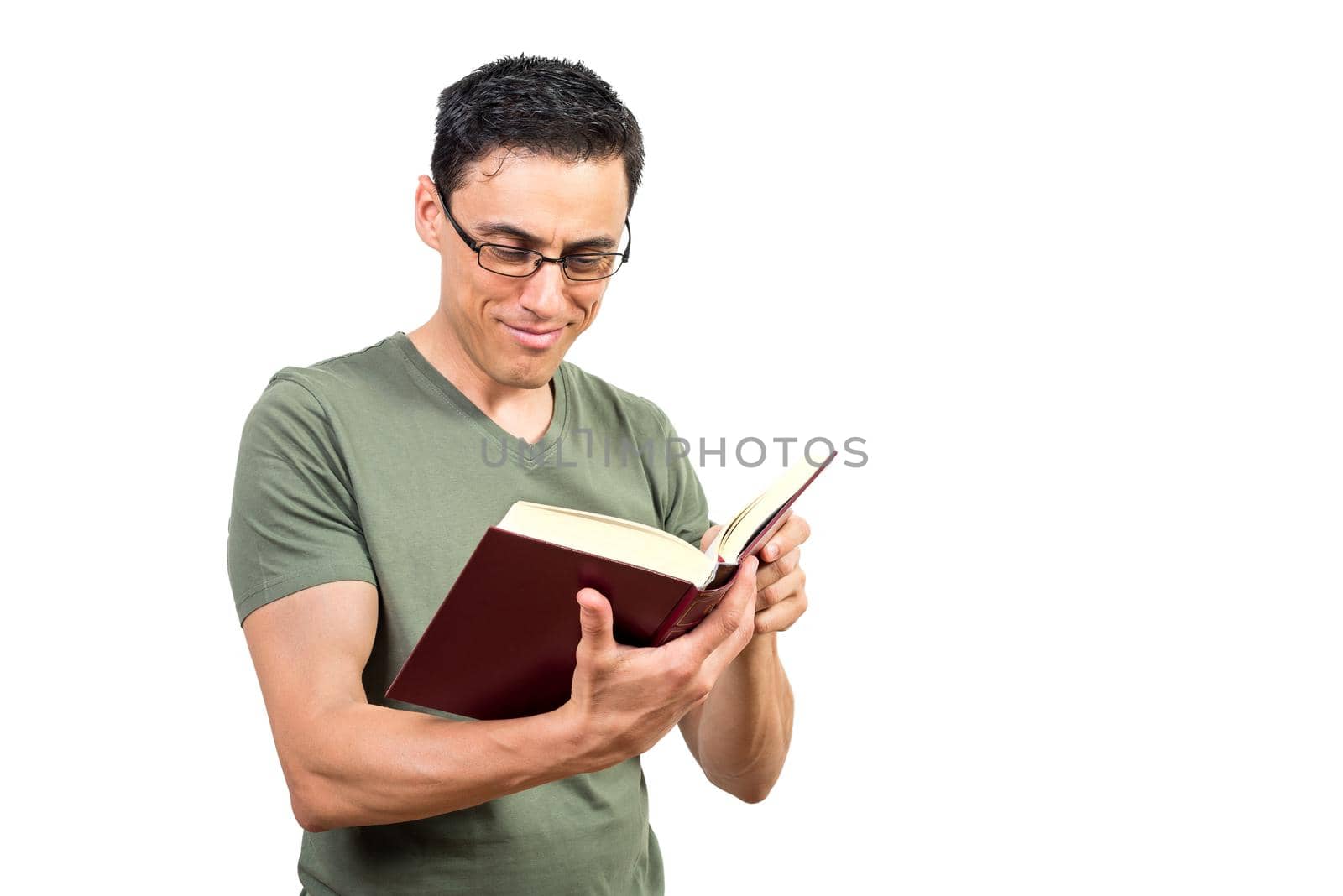 Positive smart male in glasses reading interesting story in book against white isolated background