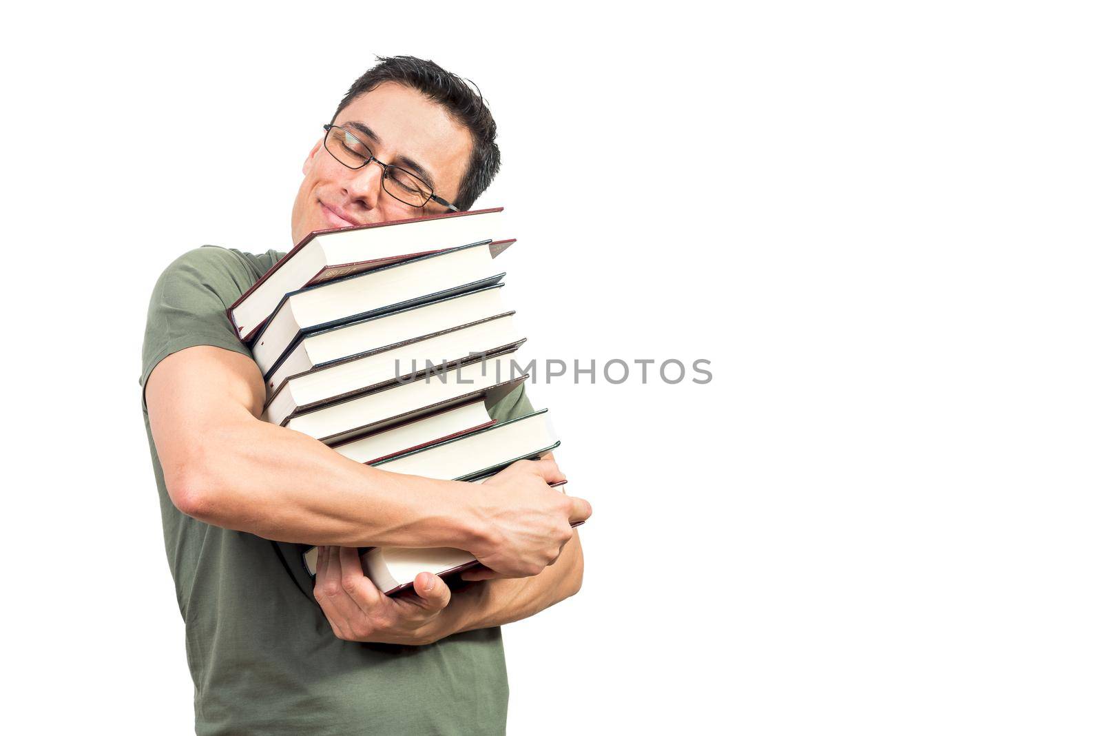 Nerdy man in glasses smiling and hugging pile of favorite books with closed eyes while standing against white background