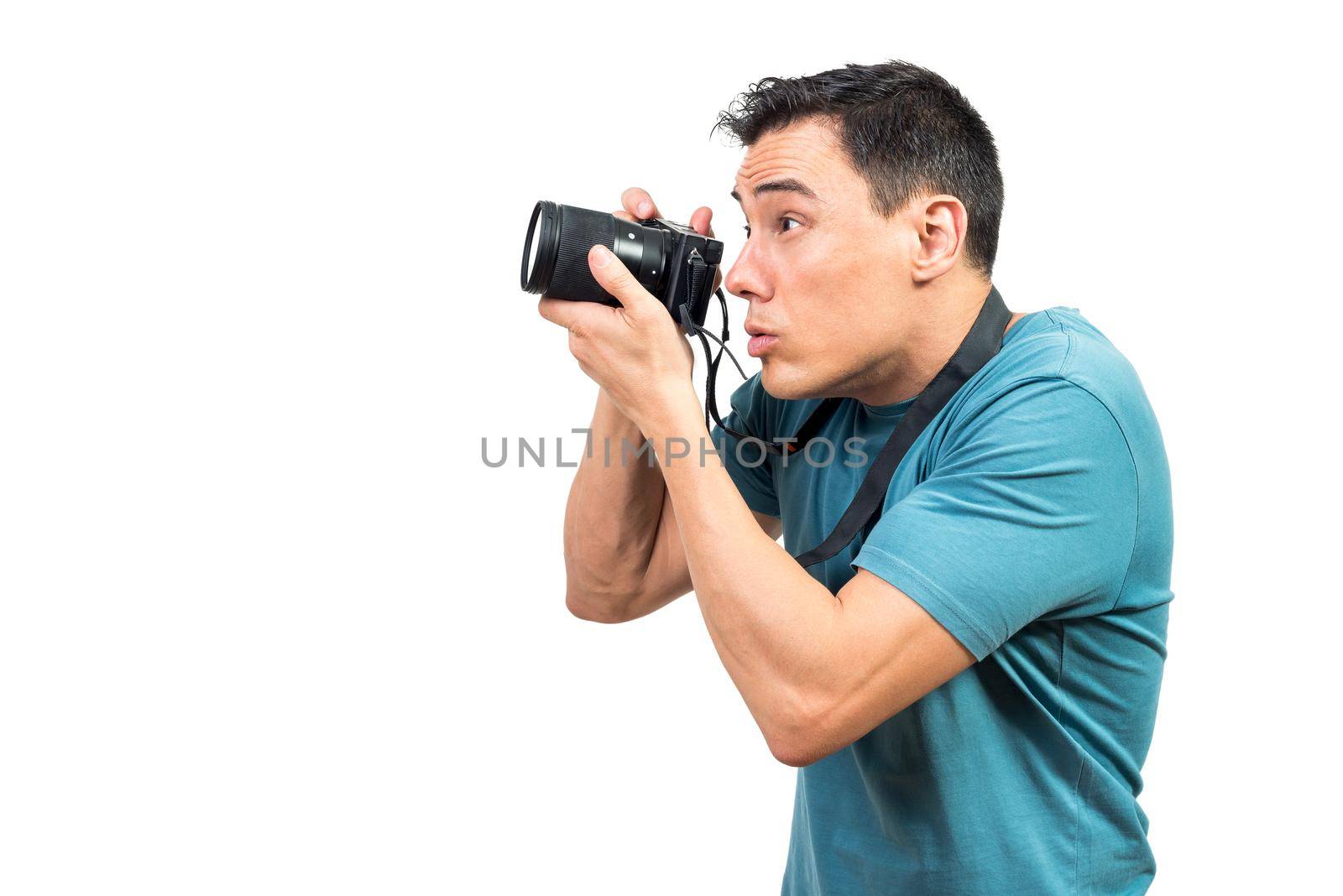 Side view of attentive male photographer taking photo on camera on white isolated background