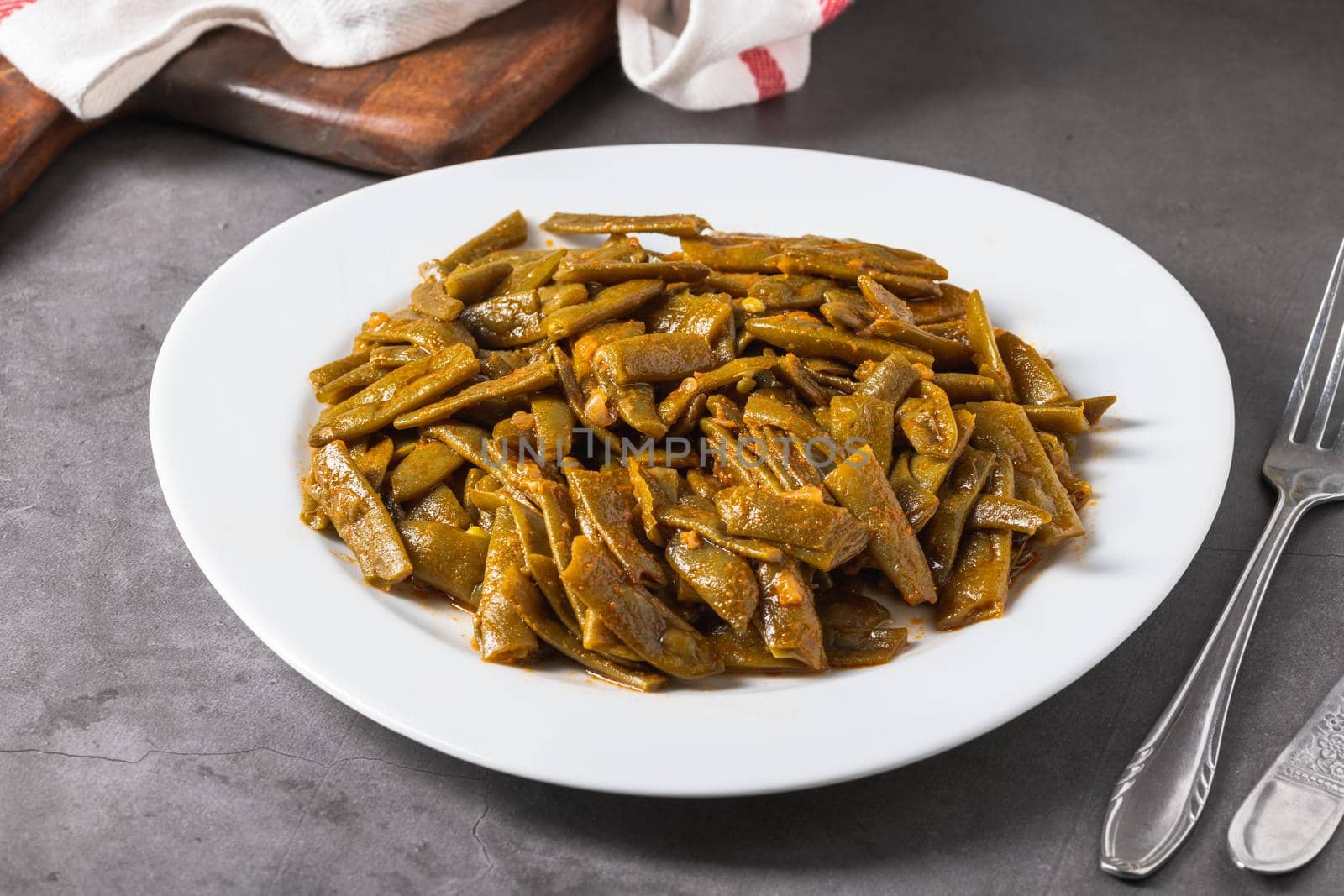 Green beans with olive oil on a white porcelain plate. Healthy eating concept