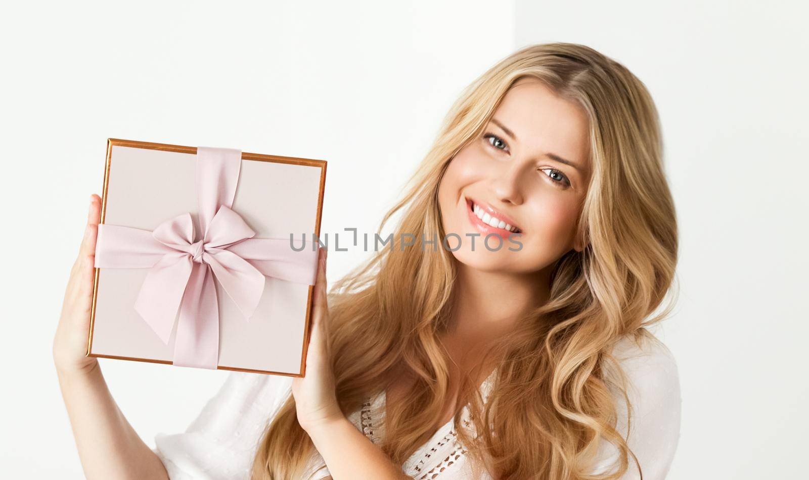 Holiday present for birthday, baby shower, wedding or luxury beauty box subscription delivery, happy woman holding a wrapped pink gift on white background