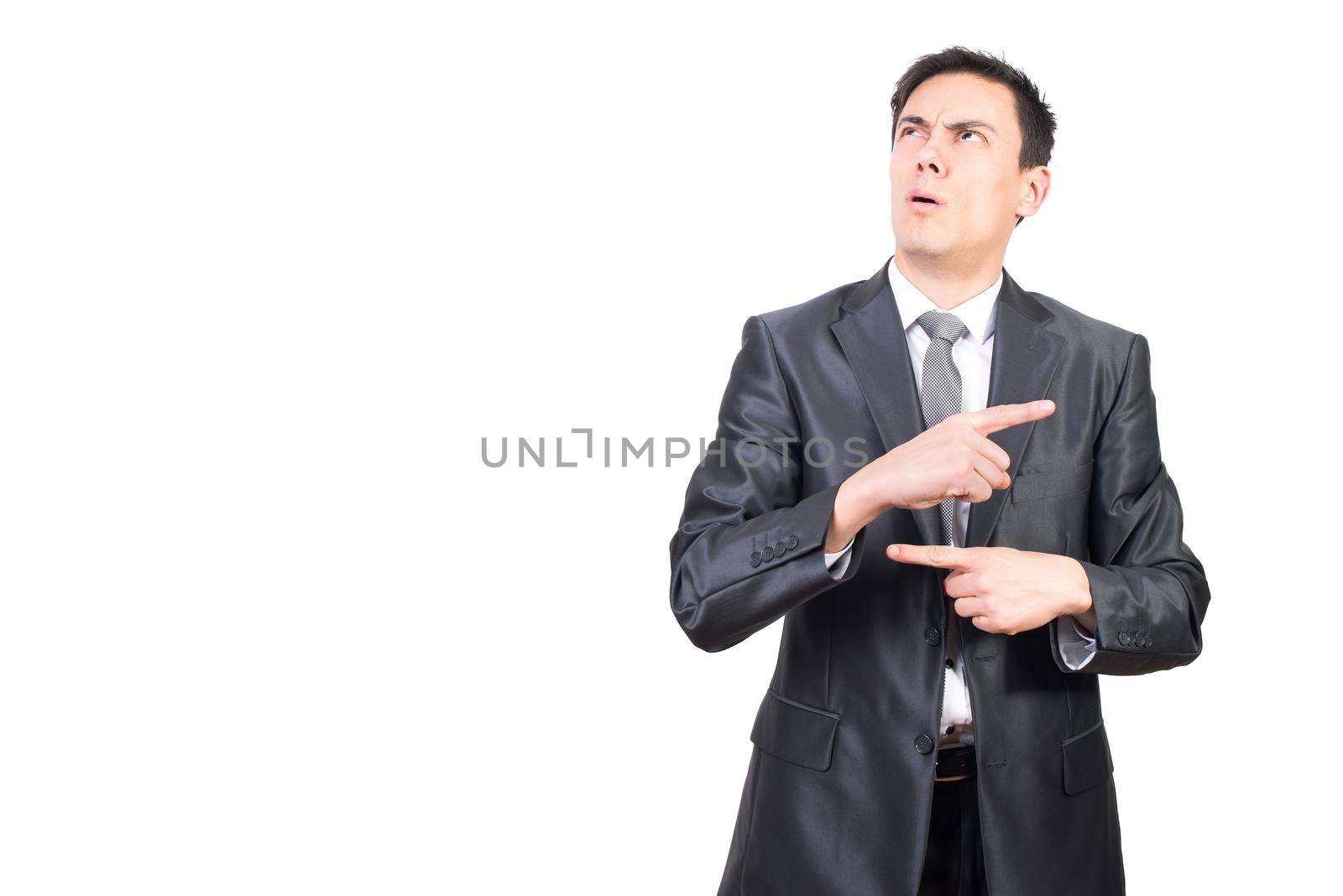 Confused young male manager in elegant suit with dark hair gesturing with fingers and looking away while counting in mind against white background