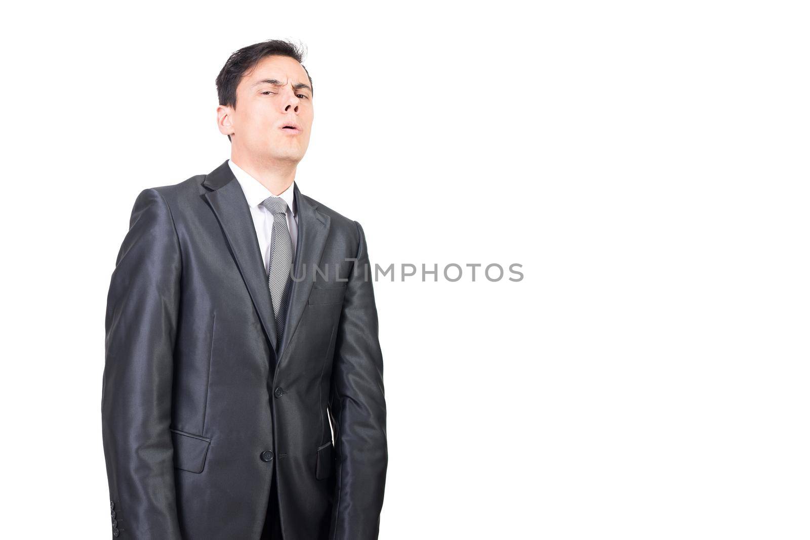 Suspicious male in classy suit and tie looking at camera with doubtful face expression against white background