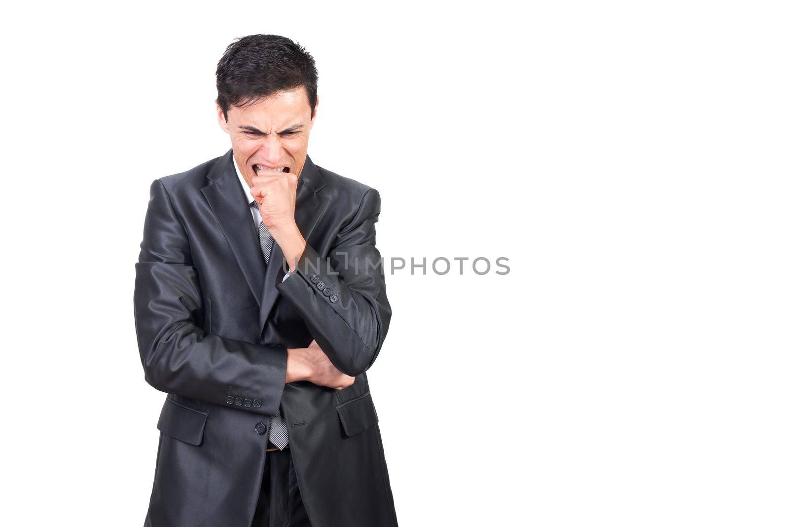 Confident male in formal costume biting fist while expressing nervous state against white background