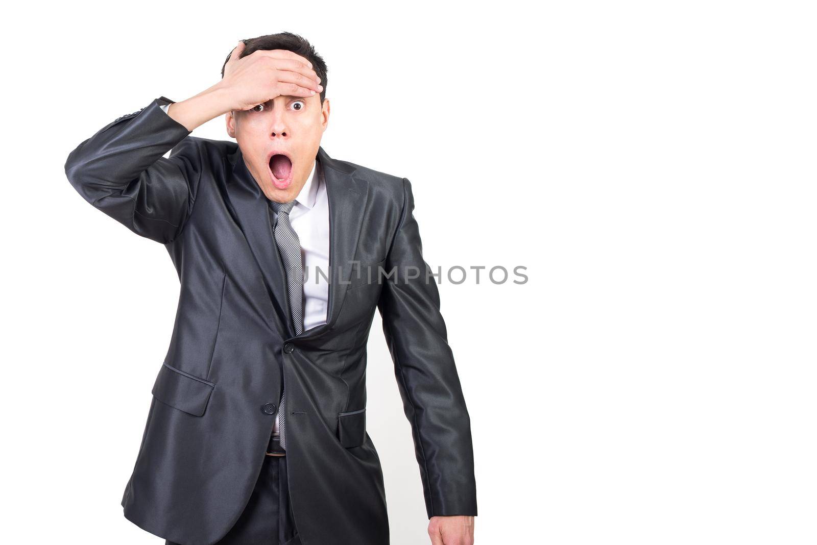 Astonished male in formal outfit touching forehead and looking at camera with opened mouth isolated on white background in studio