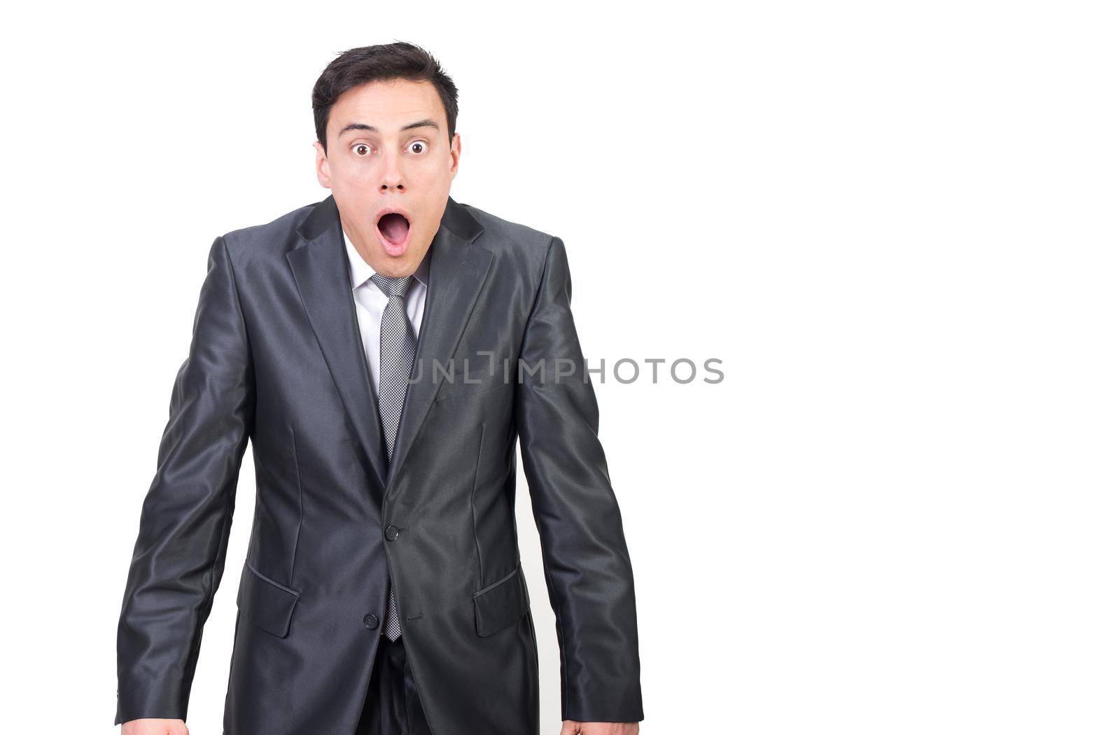 Shocked male in elegant suit looking at camera with astonished face expression and opened mouth isolated on white background in studio