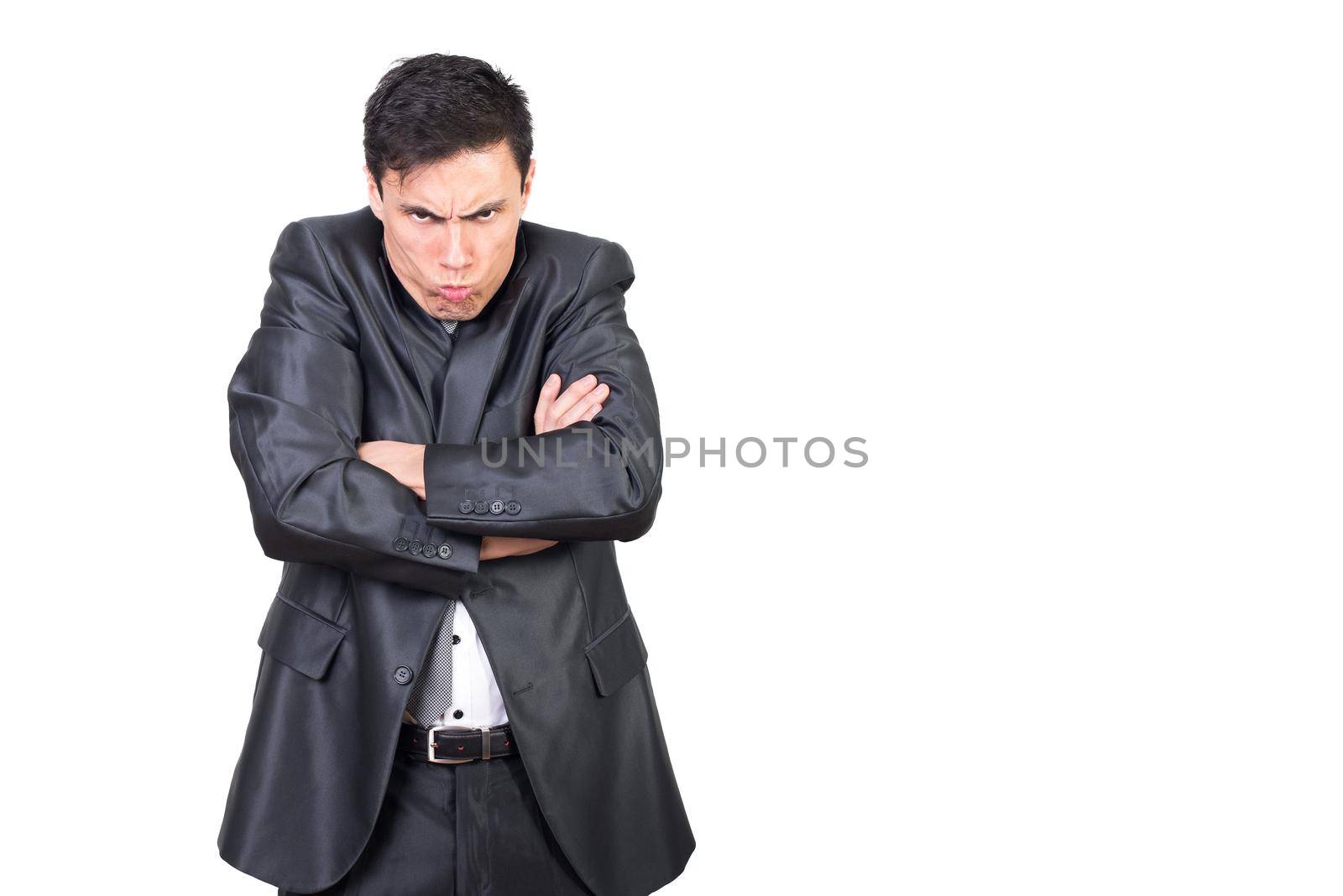 Annoyed male in formal clothes pouting lips while expressing dissatisfaction and folding hands while looking at camera with frowning face