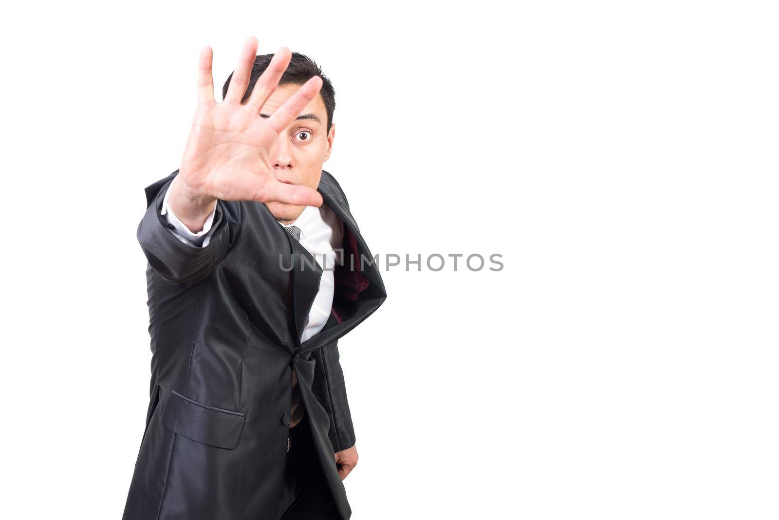 Confident excited male in classy suit showing stop gesture with palm standing against white background