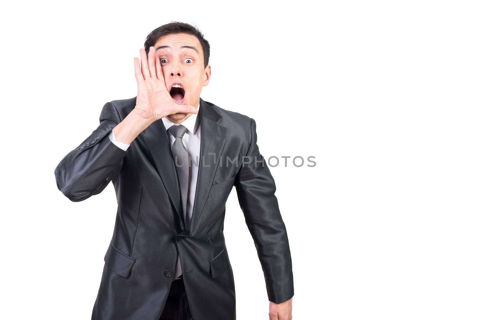 Astonished adult handsome surprised male in formal outfit talking shocking news by secret while standing against white background