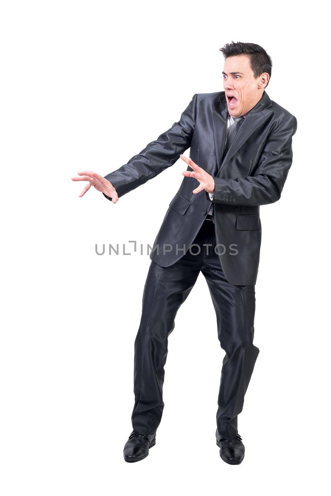 Full body of frighted man in formal suit screaming with outstretched arms while standing isolated on white background in light studio