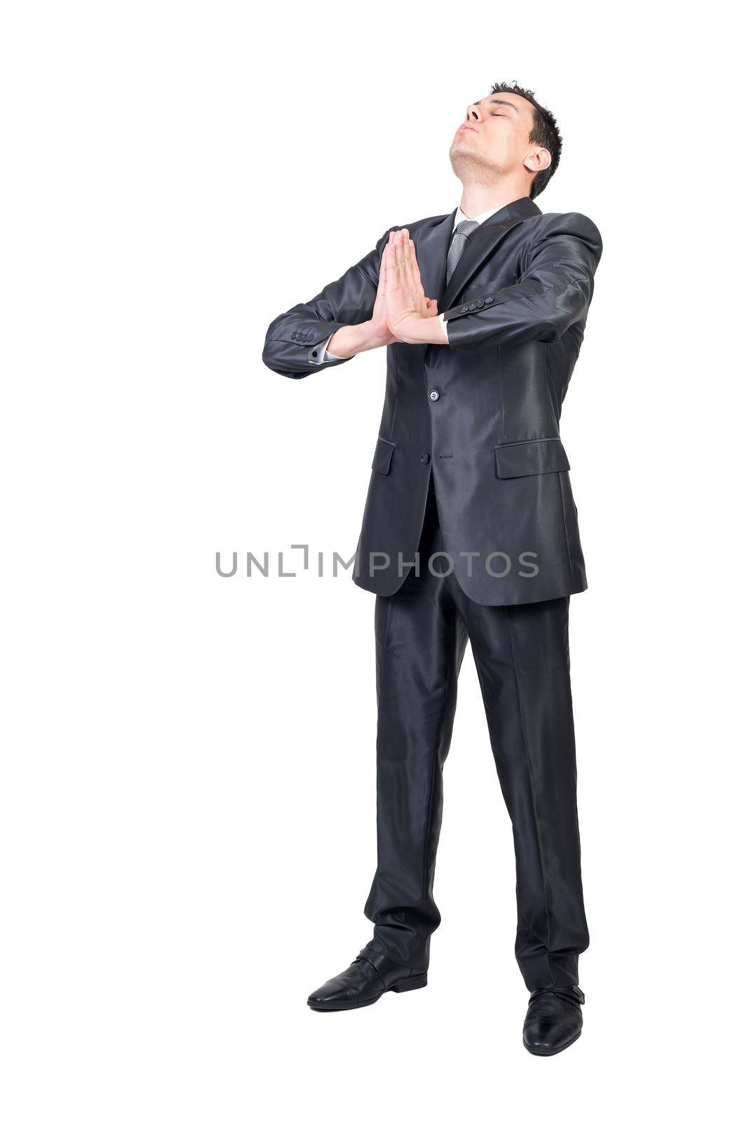 Full length of peaceful male entrepreneur in suit doing yoga with Namaste hands while meditating and relieving stress against white background