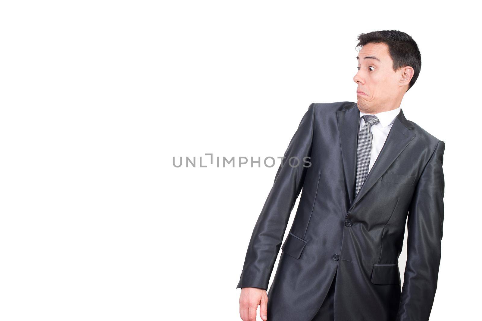 Mid shot of shocked male entrepreneur in elegant suit looking aside with astonished face expression isolated on white background in studio