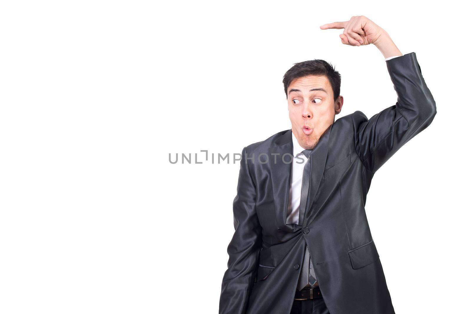 Mid shot of astonished male in elegant suit pointing aside while promoting ad isolated on white background in light studio
