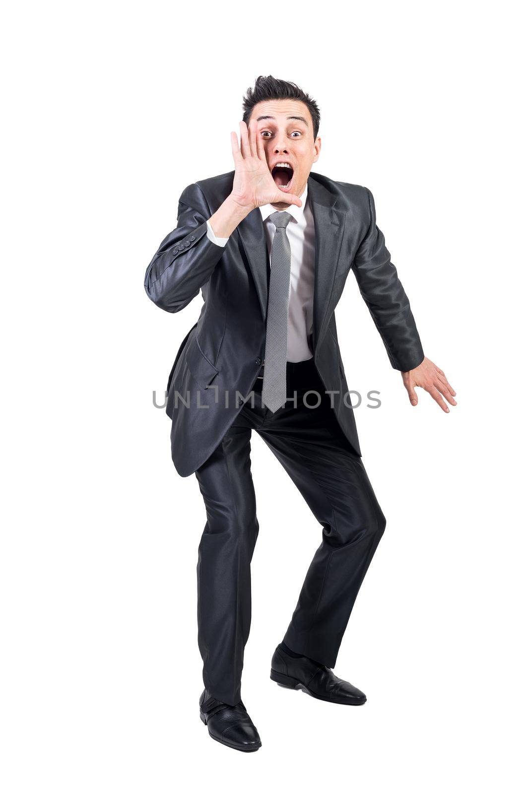 Full body of excited male entrepreneur in suit screaming and announcing good news on white background in studio