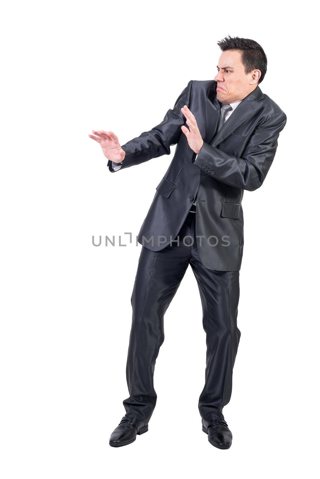Full body of unpleasant male with disgusted face in elegant suit standing isolated on white background in modern light studio