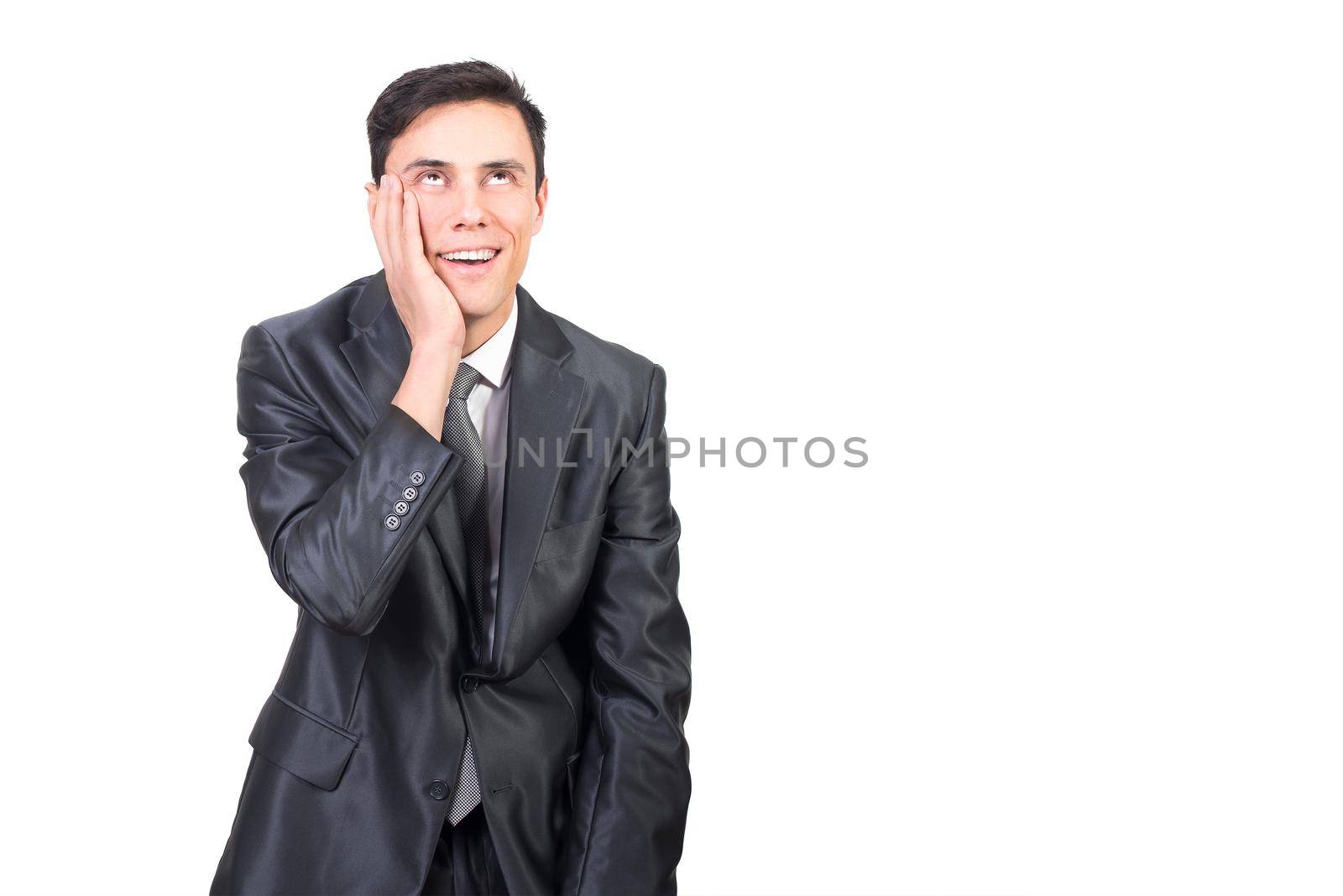 Cheerful male in elegant suit touching face with hand and expressing pleasure standing against white background