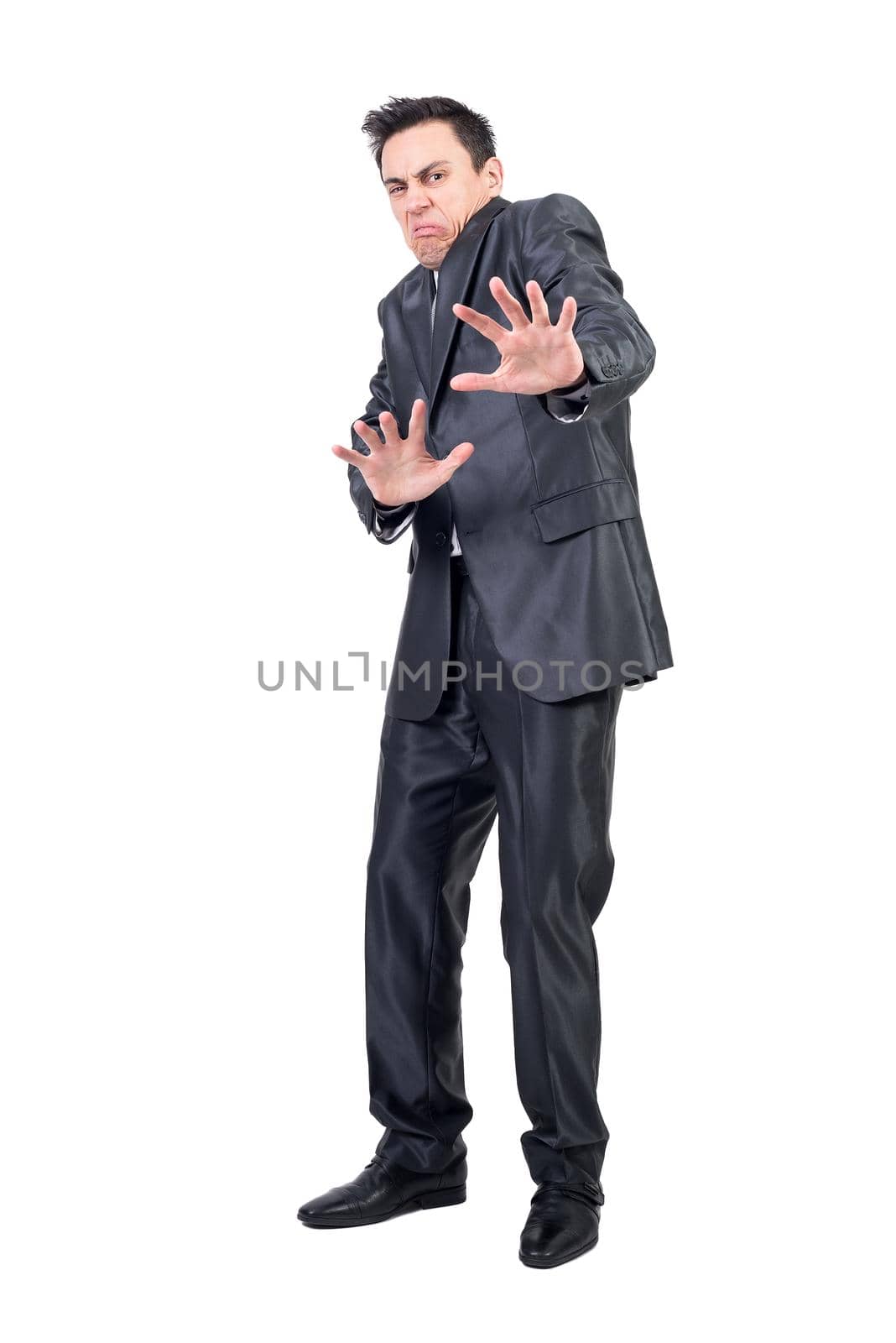Full length of squeamish young man with dark hair in classy suit showing stop sign and making disgusting face while standing against white background