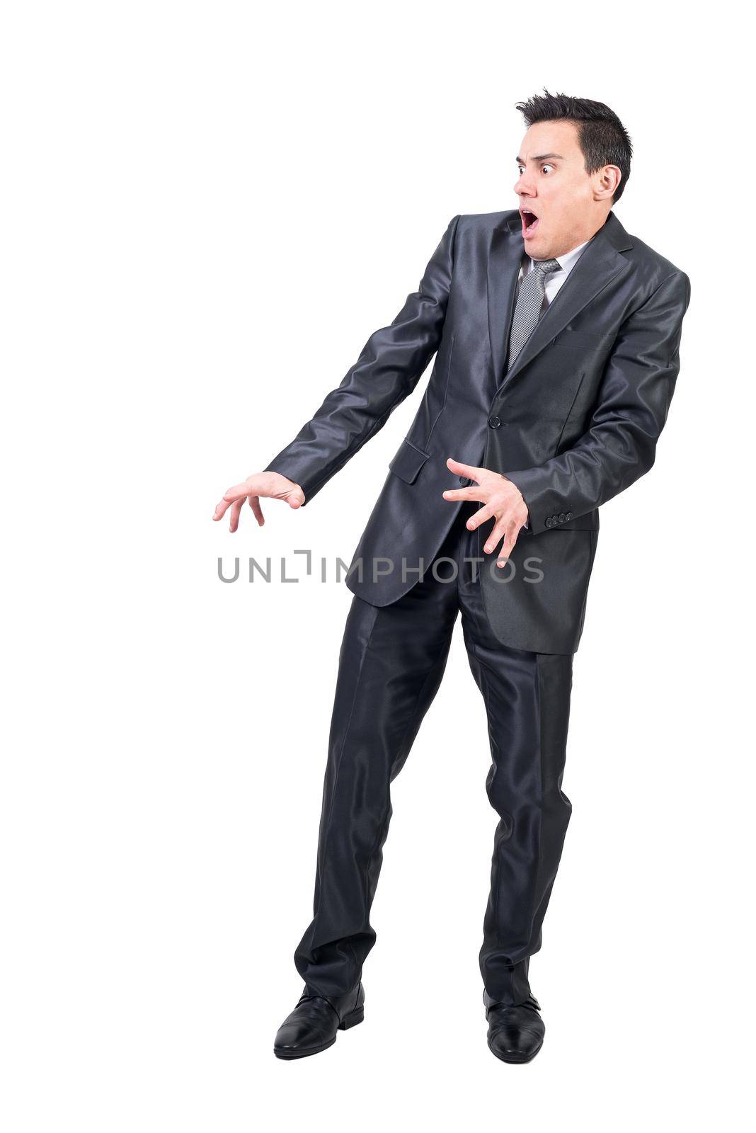 Full body of fearful male in formal suit standing isolated on white background with opened mouth and astonished face in light studio