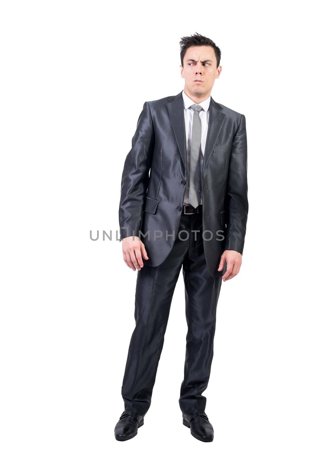 Full body of distrusted male in elegant suit looking away with doubtful face expression isolated on white background in studio