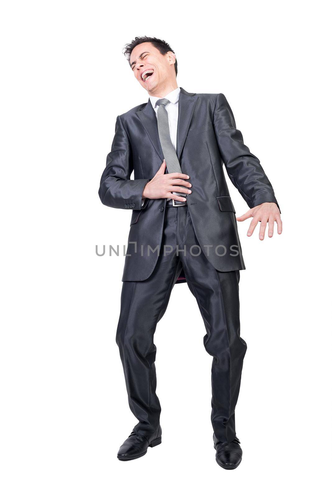 Full body of joyful businessman in classy suit laughing with opened mouth and touching tummy in studio against white background