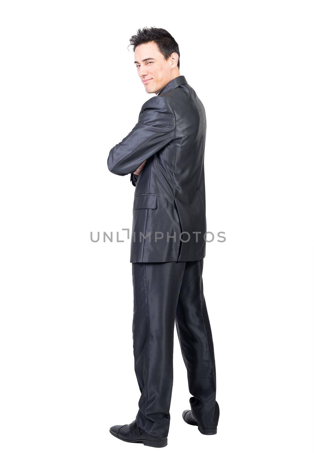 Full body of content male in formal suit looking over shoulder at camera with squinting eyes isolated on white background