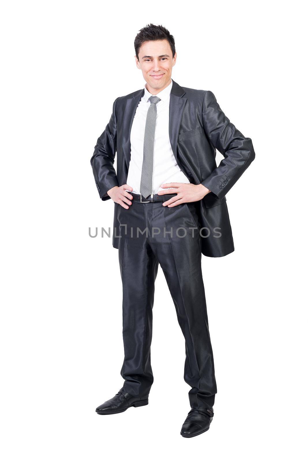 Full body of positive male in formal suit looking at camera with hands on waist isolated on white background in studio