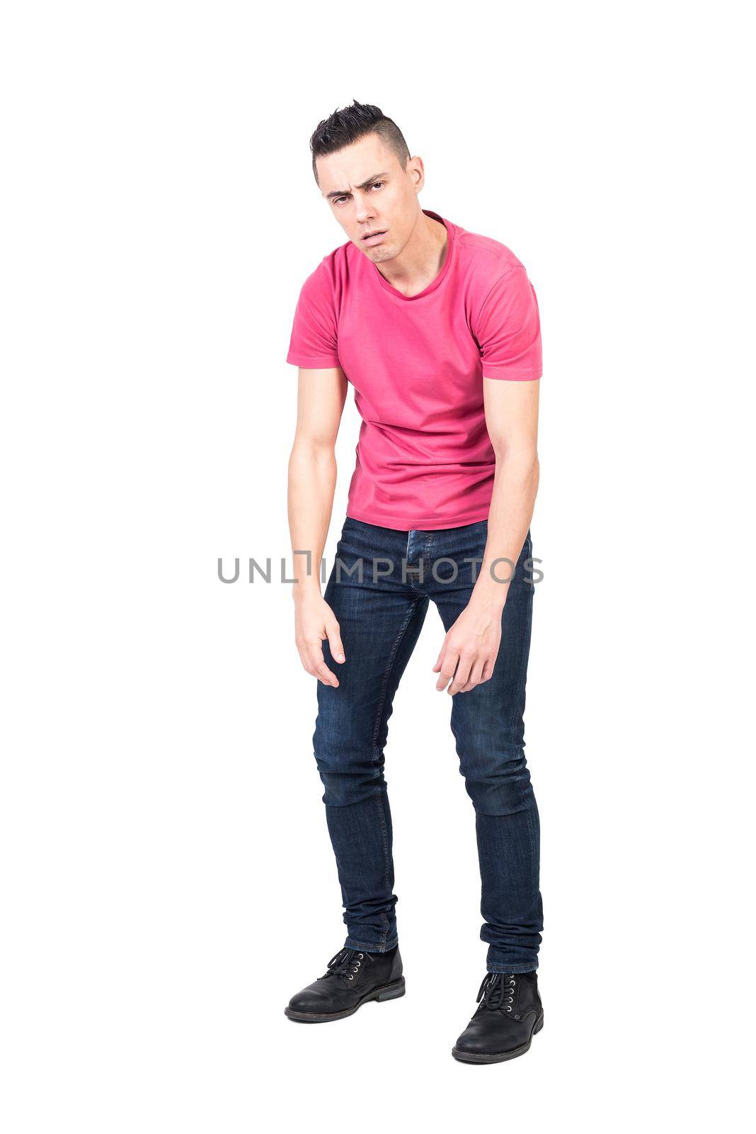 Tired male in casual clothes with round shoulders looking at camera and frowning while taking break against white background