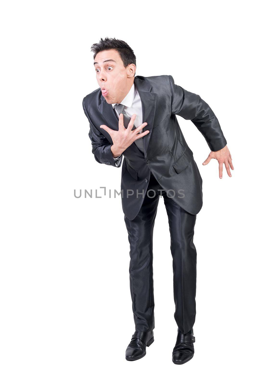 Full body of young male entrepreneur in classy suit with dark hair making grimace and vomit gesture against white background