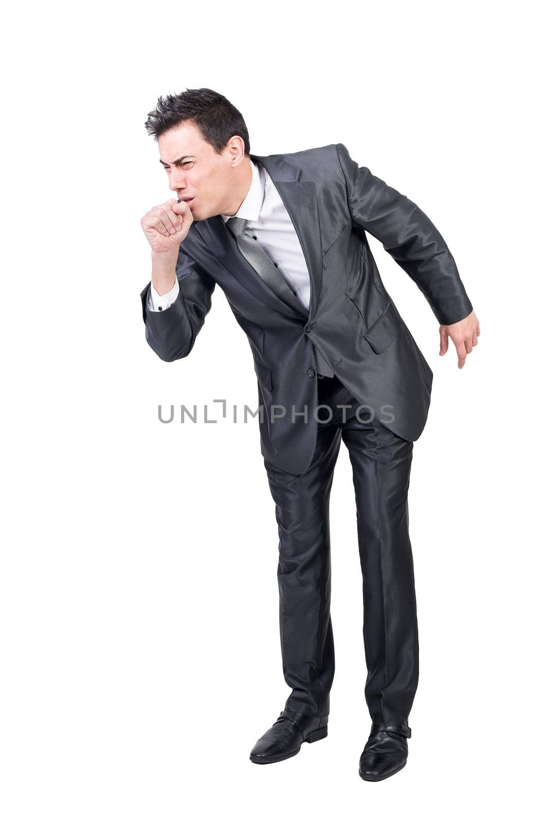 Full length of sick young male manager with dark hair in formal outfit coughing while standing against white background