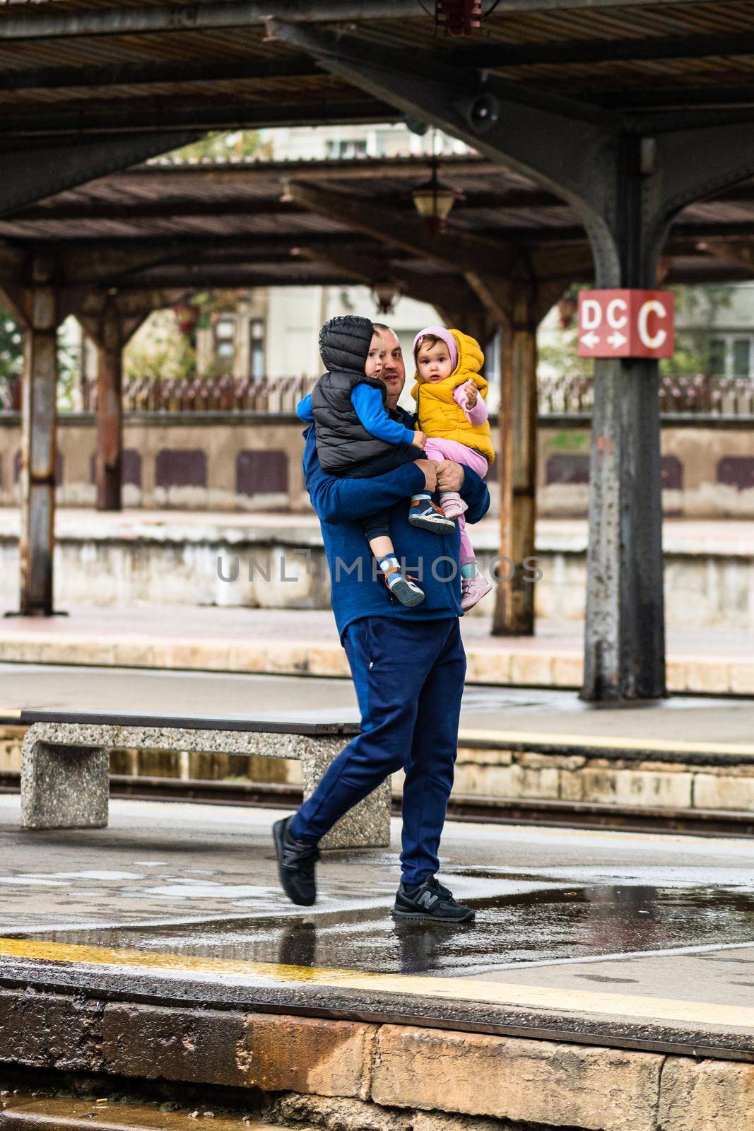 Tourist pulling luggage. Commuters walking at railroad station platform in Bucharest, Romania, 2022