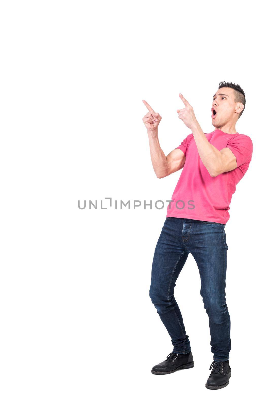Full body man in casual clothes with opened mouth pointing away while celebrating victory against white background