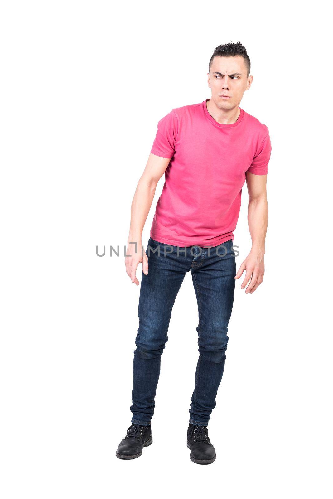 Full length wary male in casual clothes frowning and looking away with suspicion against white background