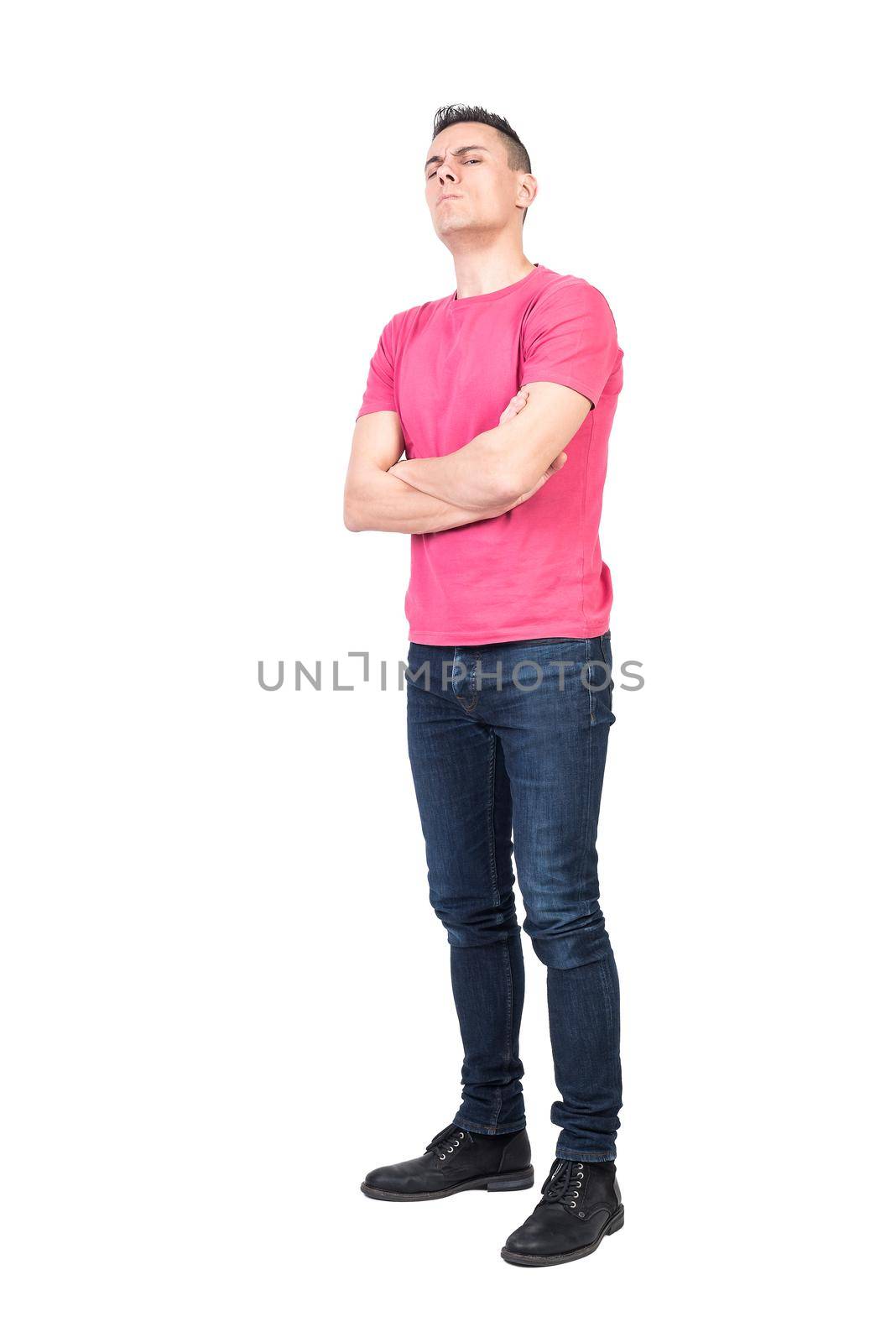 Full body skeptic man in casual clothes folding arms and looking at camera with frown against white background