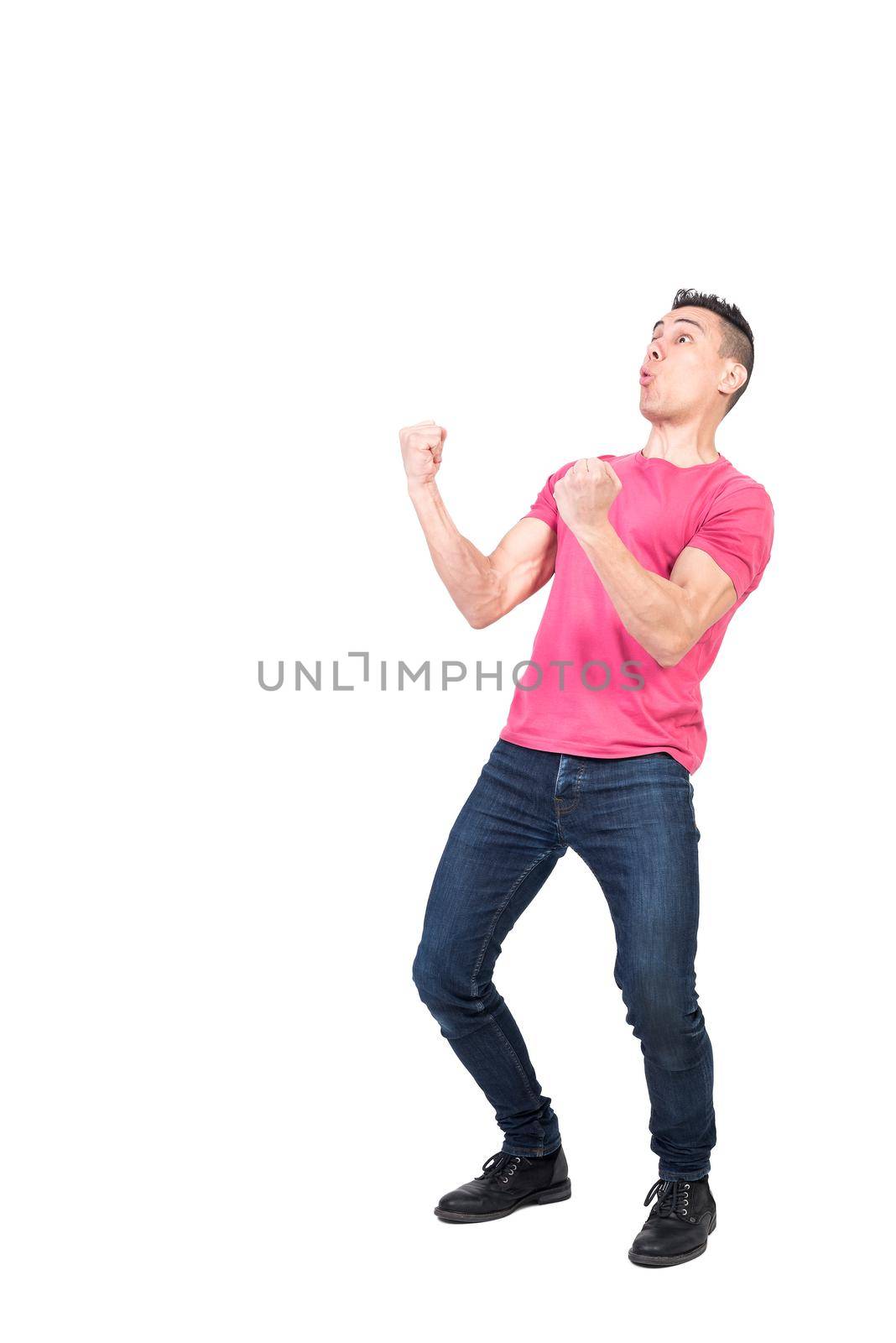 Full length victorious man in casual clothes clenching fists and pouting lips while celebrating success isolated on white background