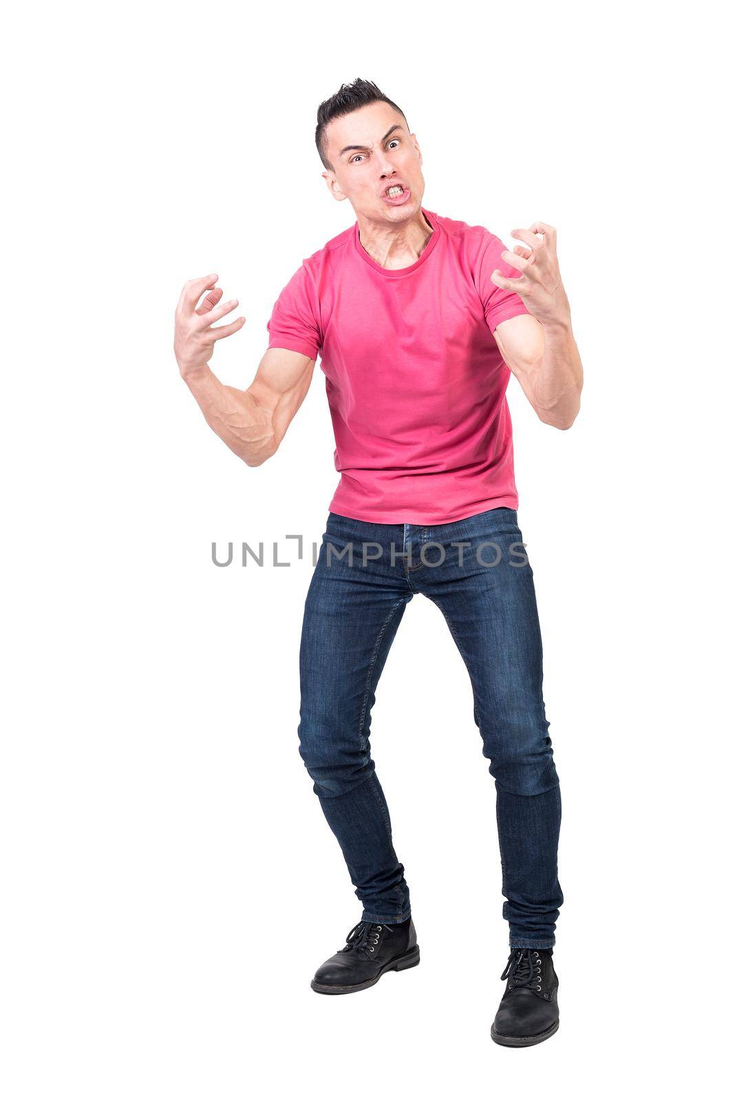 Full length of expressive young hysterical guy in casual clothes with dark hair shouting and gesturing with hands nervously while standing against white background and looking at camera