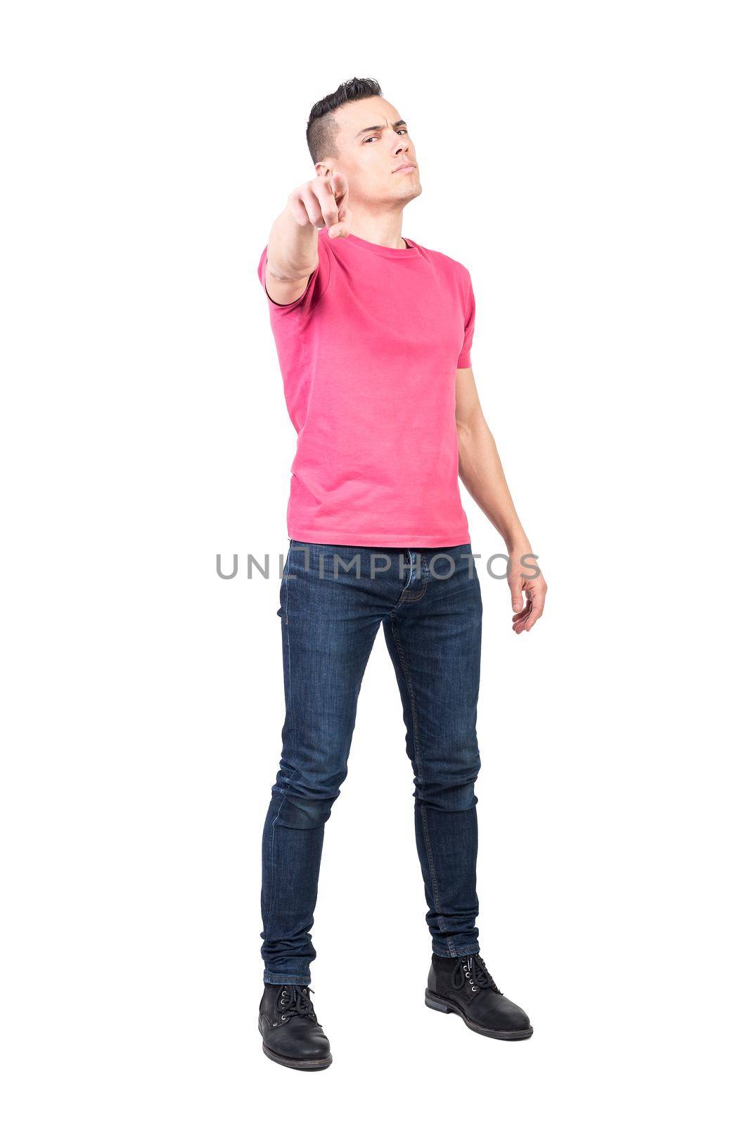 Full body of self assured male model in casual outfit pointing in front and choosing you on white background