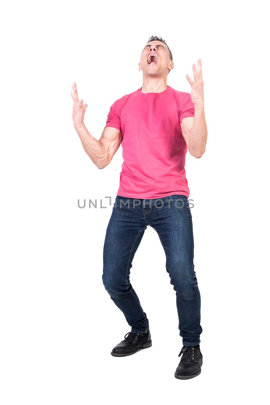 Full body of suffering young male in pink t shirt and jeans screaming desperately with closed eyes against white background