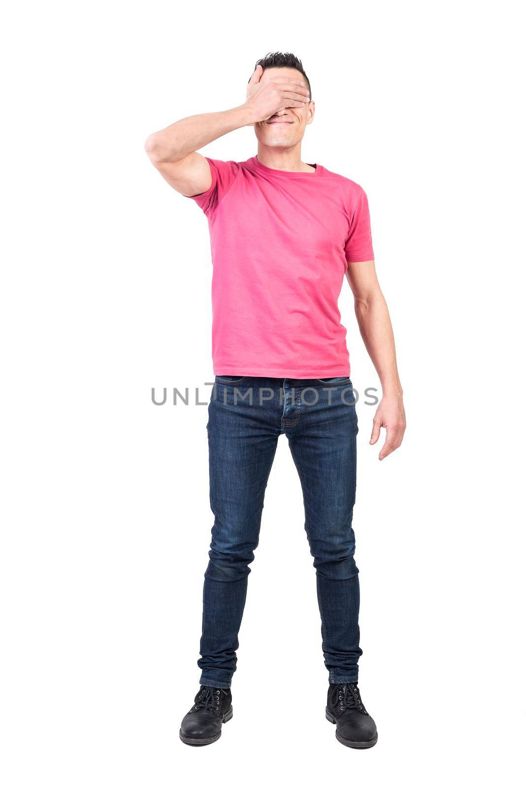 Full body of covering face as refusing to look and waiting for surprise while standing against white background