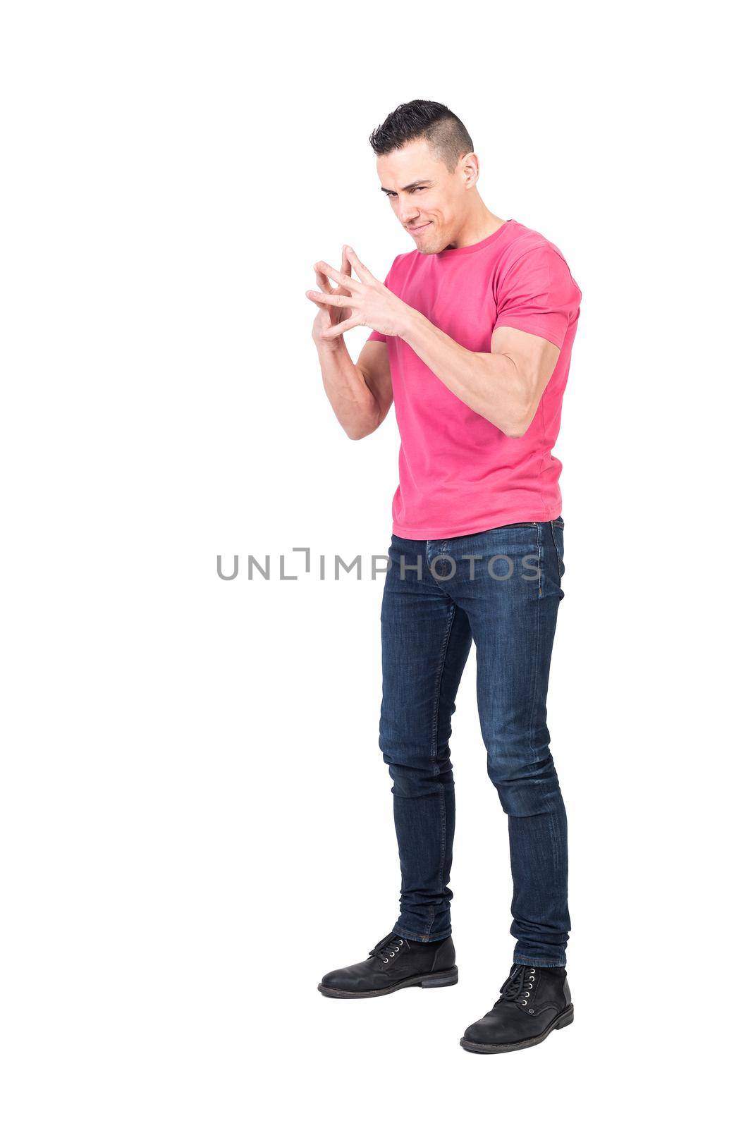 Full length of cunning young man with dark hair in t shirt and jeans connecting fingers and looking at camera against white background
