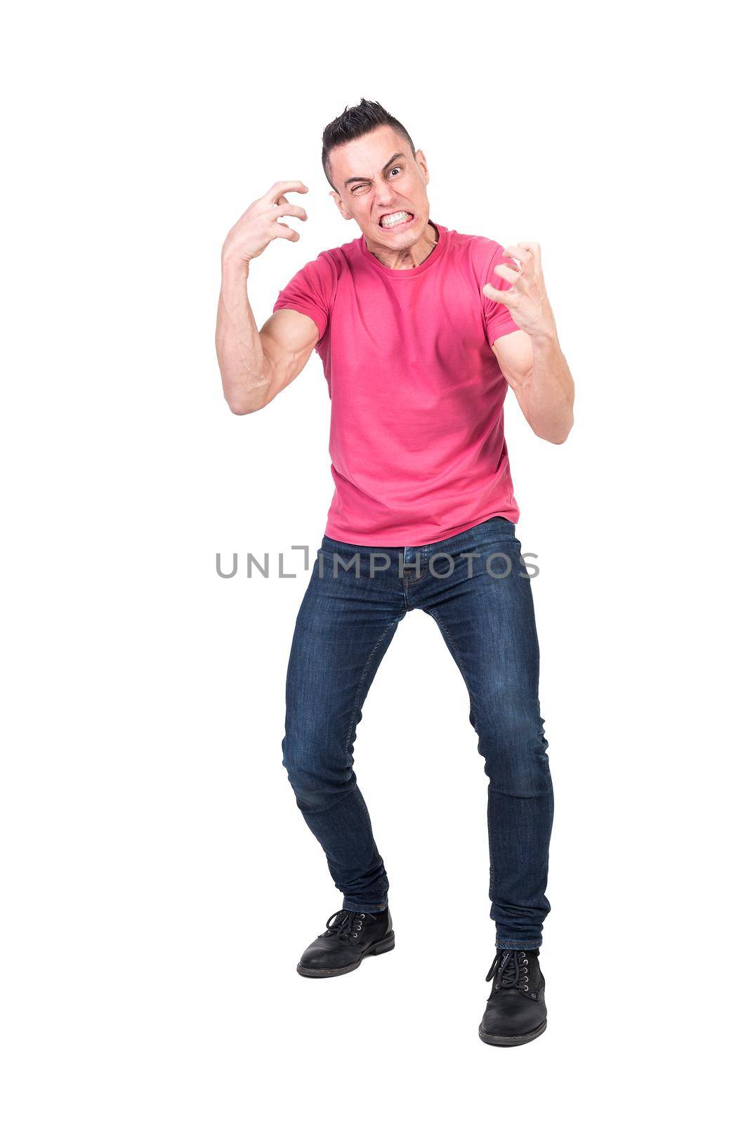 Full body of young nervous guy with dark hair in casual clothes gesturing hysterically and grinding teeth at camera against white background