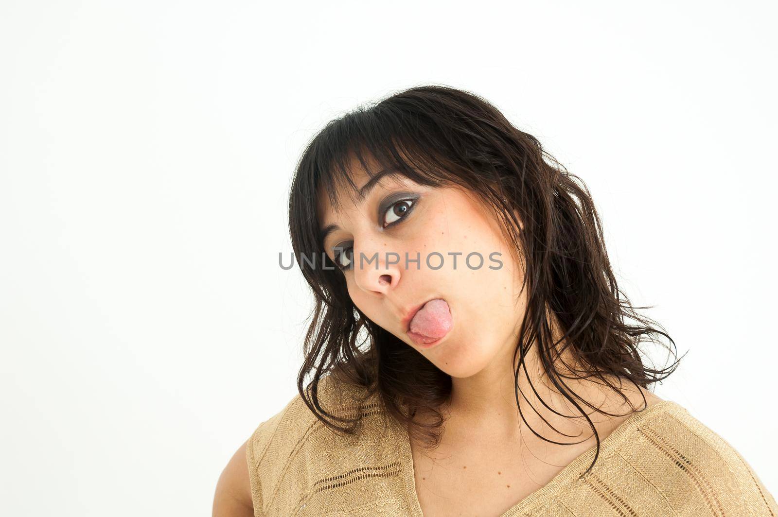 Pretty brunette girl sticking out her tongue looking at camera, with long hair, on white background, close up