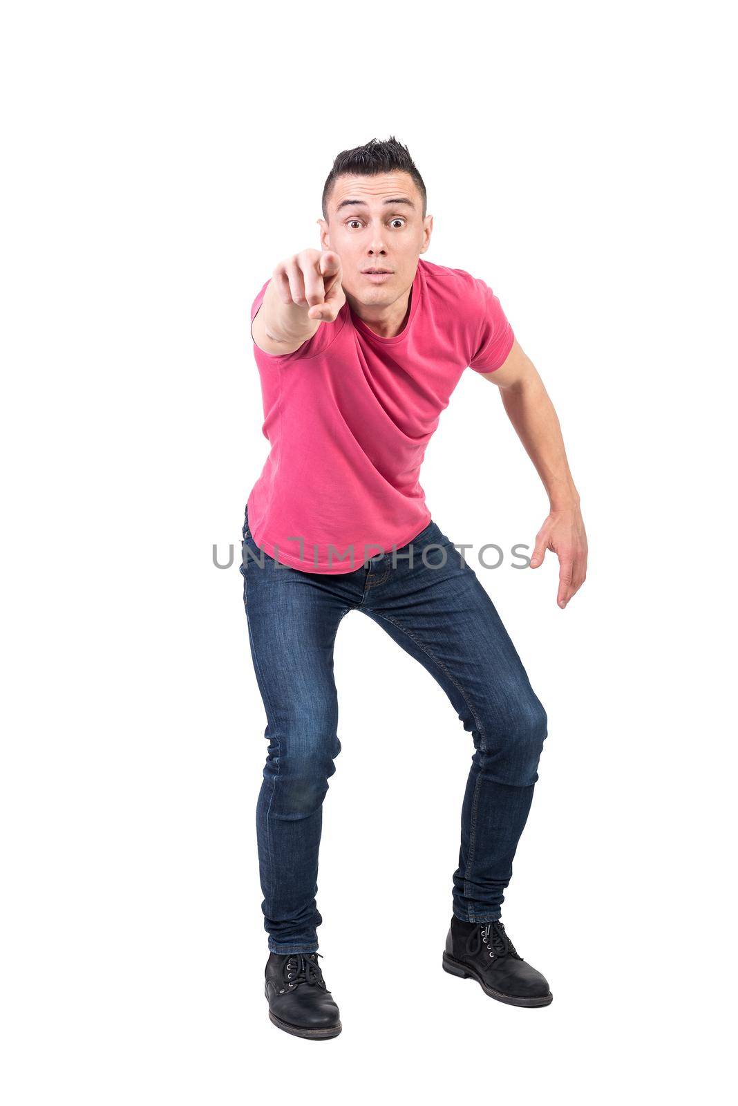 Full body of astonished male in casual clothes pointing and looking at camera with shocked face isolated on white background in studio