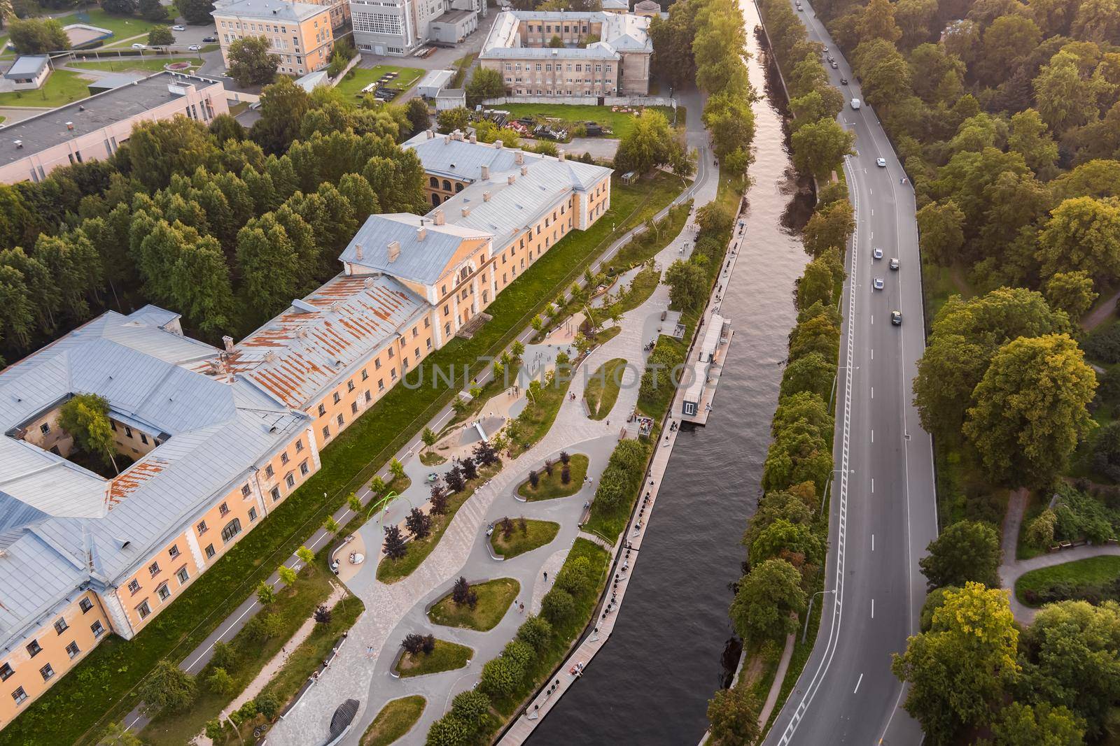 Aerial view of the public park of the Karpovka River Embankment in St. Petersburg at sunset, Russia, recreation areas, benches and amphitheater, botanical garden opposite the park. High quality photo