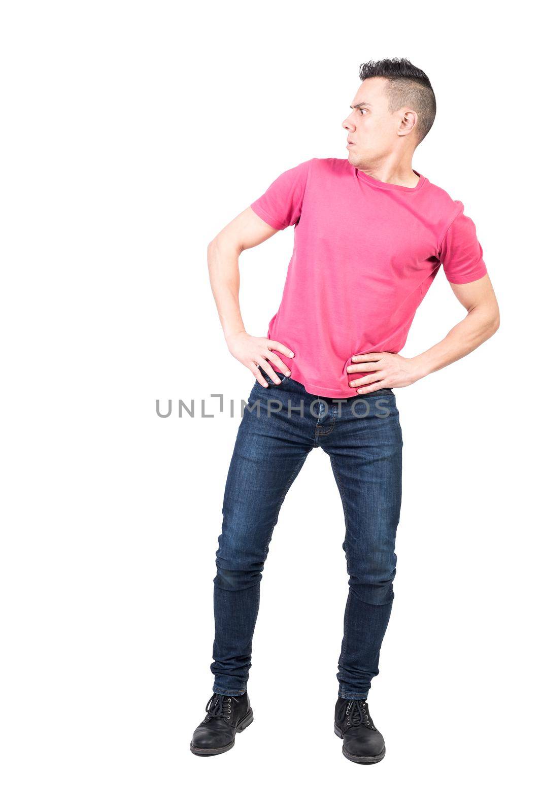 Full body of shocked male in casual clothes standing with hands on waist isolated on white background in light studio