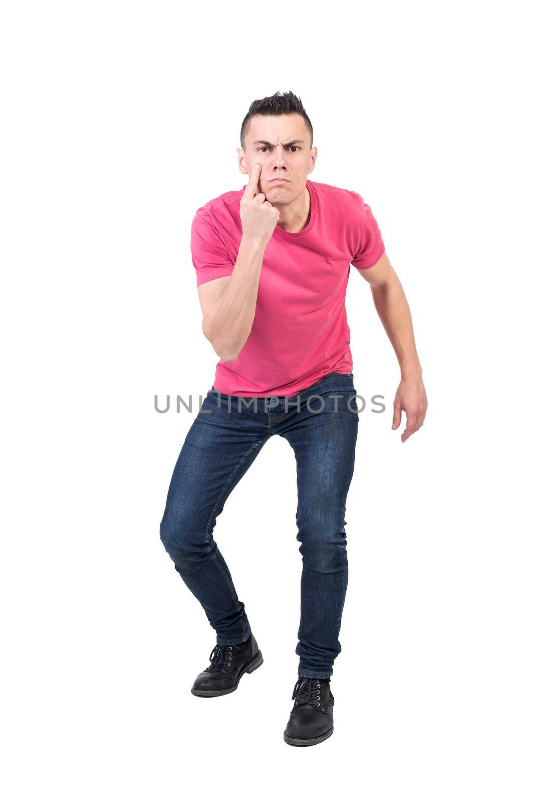 Full body of male guard pointing at eye and looking at camera with confident face expression isolated on white background in light studio