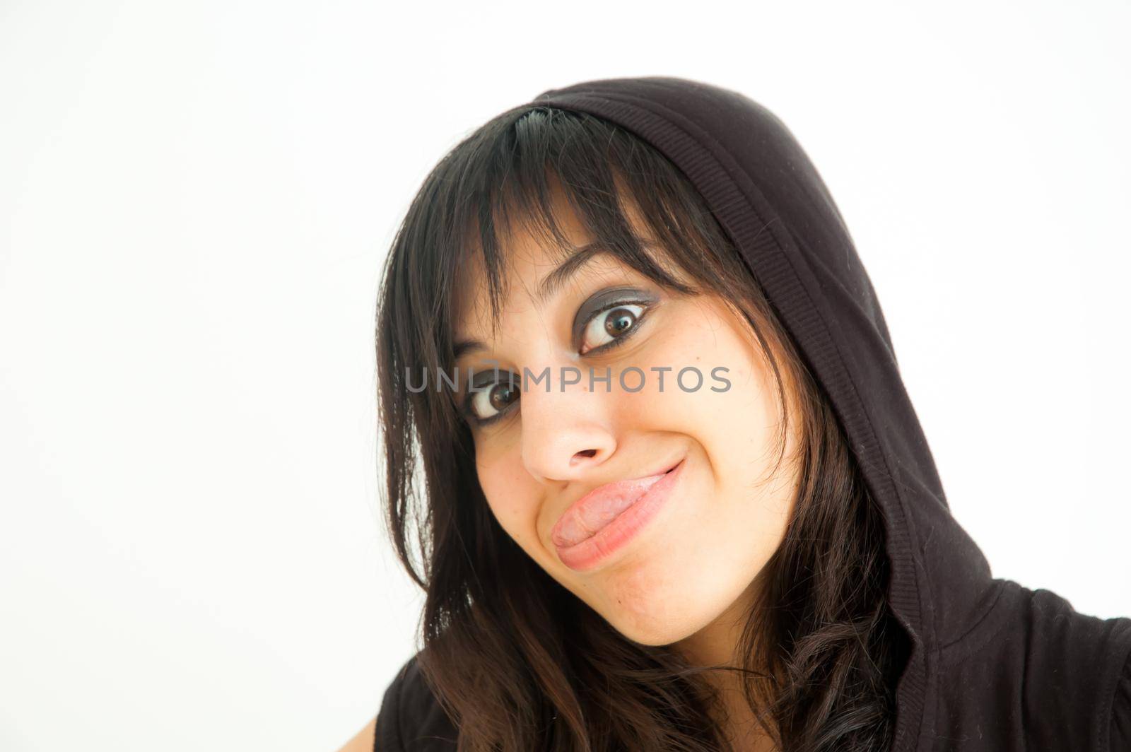 Brunette and crazy girl sticking out her tongue looking at camera, on white background, close up