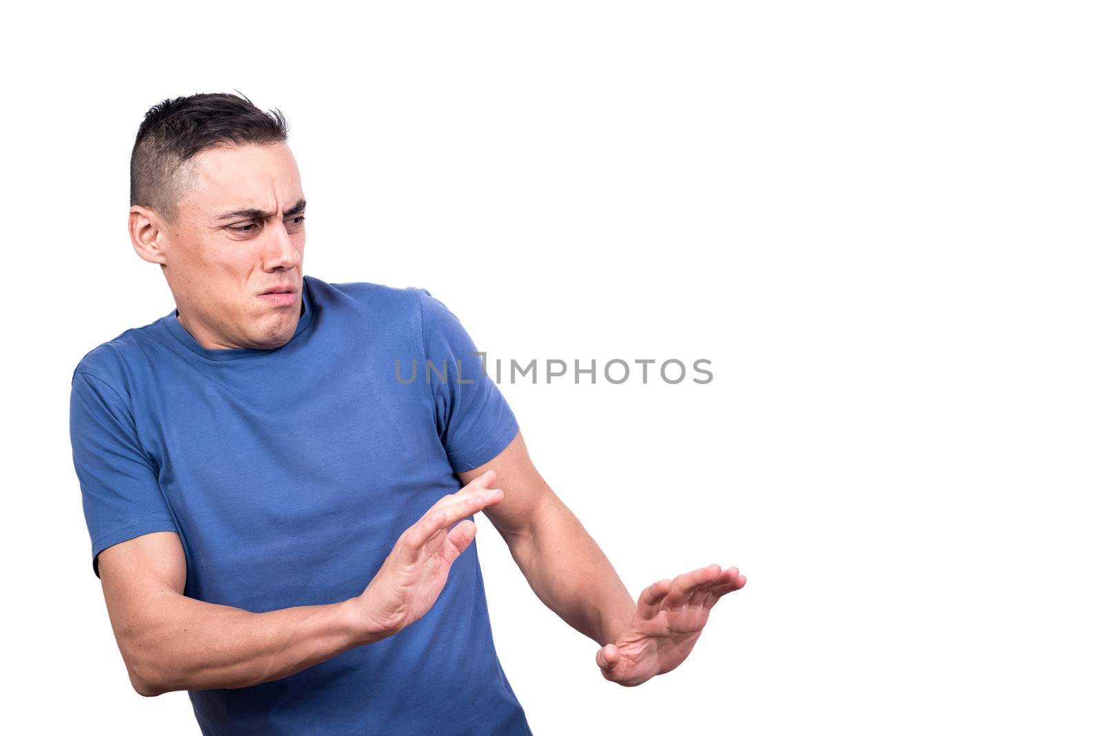 Studio portrait with white background of a man protecting himself while gesturing to move away