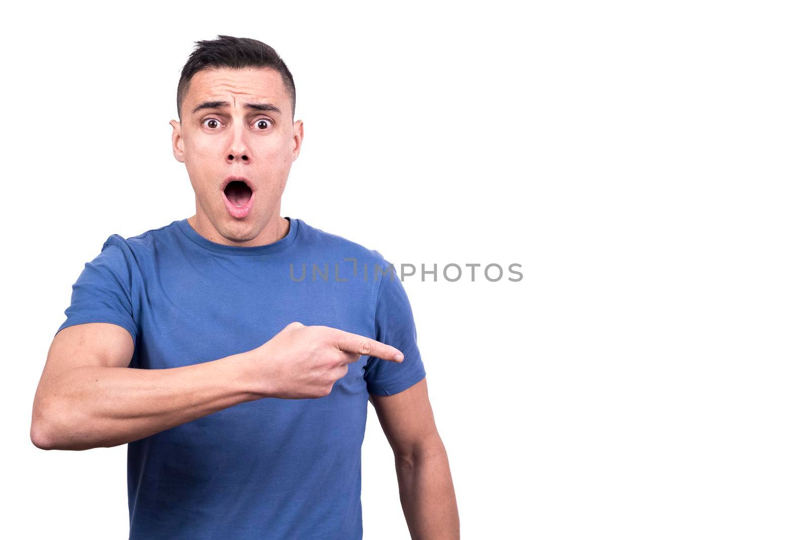 Studio portrait of a man pointing to a side with surprise expression in a white background