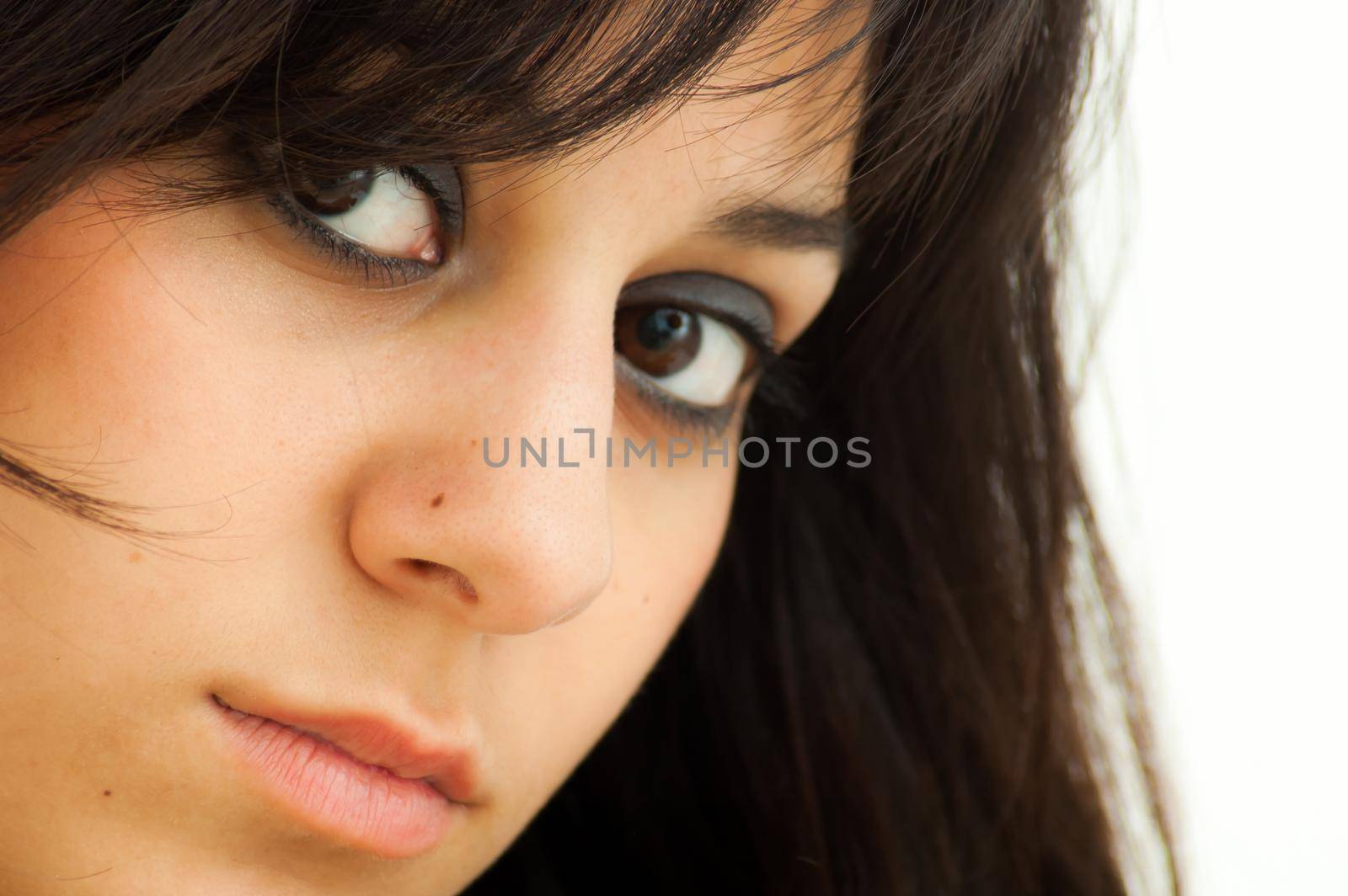 Pretty brunette girl looking straight ahead, on white background, close up