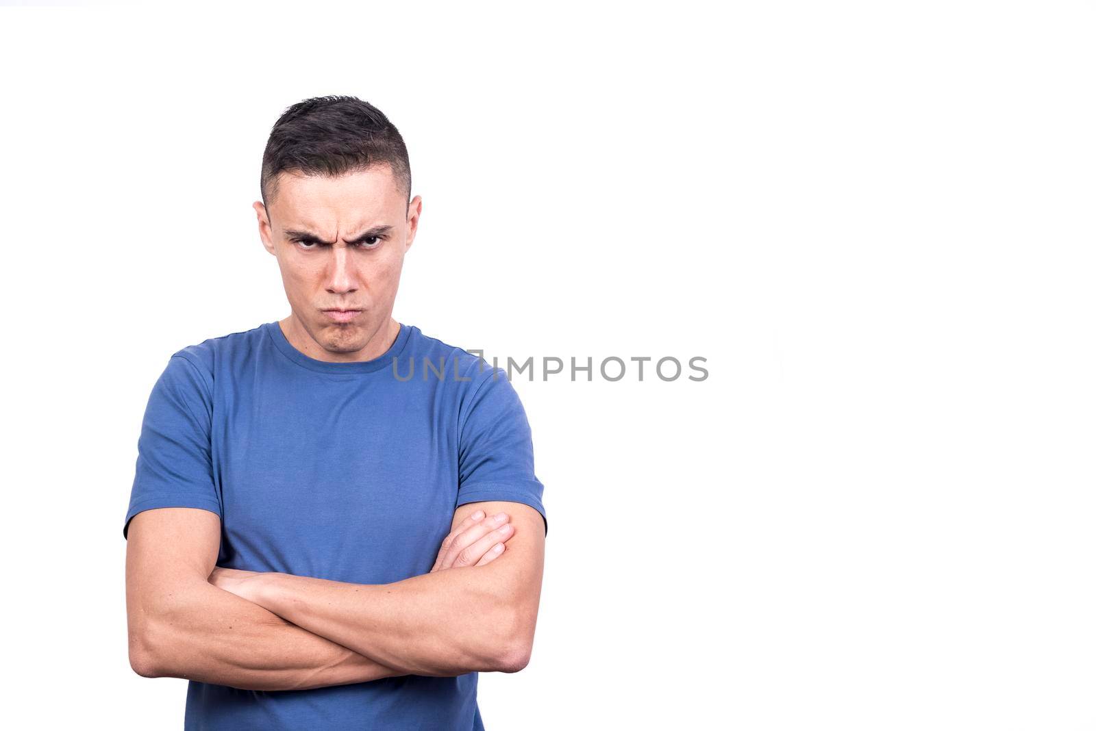 Studio portrait of an anger man with his arms crossed with a white background